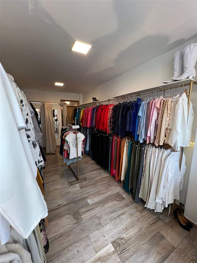 Percheros del local con prendas de todos los colores